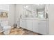 Bright bathroom featuring a double sink vanity, tiled floors, and a large framed mirror at 11684 Park South Loop, Parker, CO 80138