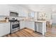 Modern kitchen with white cabinets, granite countertops, stainless steel appliances, and hardwood floors at 11684 Park South Loop, Parker, CO 80138