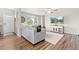 Bright living room with modern decor, large windows, a sectional sofa, and wood floors at 11684 Park South Loop, Parker, CO 80138