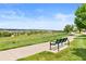 Scenic view of a park walkway with a bench and a picturesque residential backdrop at 11684 Park South Loop, Parker, CO 80138
