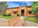 Charming condo exterior featuring a well-maintained lawn and wooden bridge entrance at 3335 S Ammons St # 6-105, Lakewood, CO 80227