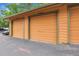 Image features individual garages painted orange with dark green trim at 3335 S Ammons St # 6-105, Lakewood, CO 80227
