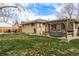 A cozy backyard featuring a well-kept lawn, a hot tub under a pergola, and a charming patio area at 7039 Otis Ct, Arvada, CO 80003