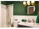 Well-lit bathroom with shower, round mirror, modern vanity, and eye-catching colors at 7039 Otis Ct, Arvada, CO 80003