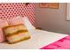 Bedroom with pink lip wallpaper and fluffy pillow at 7039 Otis Ct, Arvada, CO 80003