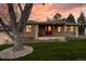 Charming single-story home boasts a well-manicured lawn and inviting red front door at 7039 Otis Ct, Arvada, CO 80003