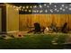 Inviting backyard fire pit area with Adirondack chairs, string lights, and cornhole boards at 7039 Otis Ct, Arvada, CO 80003