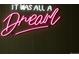 A bright pink neon sign that says 'It Was All A Dream' on a dark green wall at 7039 Otis Ct, Arvada, CO 80003