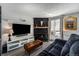Living room with a fireplace, comfy couch, and a large TV at 17111 E Stanford Ave # C, Aurora, CO 80015