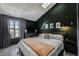 Spacious bedroom with a king-size bed, dark walls, and large window at 17111 E Stanford Ave # C, Aurora, CO 80015
