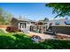 Expansive backyard featuring a stone patio, outdoor seating, and a well-maintained lawn, perfect for entertaining at 6995 S Kendall Blvd, Littleton, CO 80128