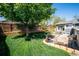 Spacious backyard featuring a lush lawn, mature tree, and patio with outdoor dining area at 6995 S Kendall Blvd, Littleton, CO 80128