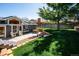 Inviting backyard featuring a patio area with seating, a lush lawn, and a beautiful shade tree at 6995 S Kendall Blvd, Littleton, CO 80128