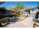 Landscaped backyard with tiered stone walls, patio, and access to the home at 6995 S Kendall Blvd, Littleton, CO 80128