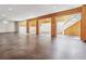 Open basement featuring wood accents and staircase, offering potential for versatile living space at 6995 S Kendall Blvd, Littleton, CO 80128