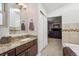 Bathroom view showcasing granite countertop, a sink, mirror, and tiled shower at 6995 S Kendall Blvd, Littleton, CO 80128