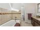 Bathroom featuring a soaking tub with tile surround and granite countertop vanity at 6995 S Kendall Blvd, Littleton, CO 80128