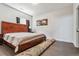 Comfortable bedroom featuring a wooden bed frame, neutral bedding, and a window for natural light at 6995 S Kendall Blvd, Littleton, CO 80128