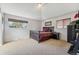A bedroom with carpet, windows, and a gray bed with purple sheets is brightly lit by an overhead light at 6995 S Kendall Blvd, Littleton, CO 80128