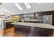 Open kitchen area with granite island, stainless appliances, and dark wood cabinetry at 6995 S Kendall Blvd, Littleton, CO 80128