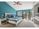 Bright bedroom with a private balcony access, a vaulted ceiling, and a large comfortable bed at 6995 S Kendall Blvd, Littleton, CO 80128
