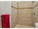 Walk-in shower featuring tile walls, a shower head and a red towel on a rack at 6995 S Kendall Blvd, Littleton, CO 80128
