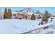 Two-story house with snow-covered yard, visible walkway, and mature trees at 2325 15Th Ave, Longmont, CO 80503