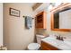 Cozy half bathroom featuring a wooden cabinet, a mirror, and a towel rack, with beige walls at 2226 Weatherstone Cir, Highlands Ranch, CO 80126