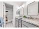 Well-lit bathroom with dual vanity, granite countertop, framed mirrors, and tiled shower at 2226 Weatherstone Cir, Highlands Ranch, CO 80126