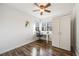 Bright bedroom with hardwood floors, ceiling fan, closet and window with a desk and chair below it at 2226 Weatherstone Cir, Highlands Ranch, CO 80126