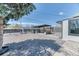 Backyard featuring a gravel area, modern pergola, complemented by the home's exterior and lush trees at 7621 Granada Rd, Denver, CO 80221