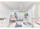 Bright bedroom featuring neutral carpet, a striped bedspread, white walls and a crib at 7621 Granada Rd, Denver, CO 80221