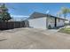 Charming single-story home features a wide driveway, lush lawn, and a classic white brick exterior at 7621 Granada Rd, Denver, CO 80221