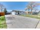 Charming single-story home features a wide driveway, lush lawn, and a classic white brick exterior at 7621 Granada Rd, Denver, CO 80221