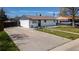 Charming single-story home features a wide driveway, lush lawn, and a classic white brick exterior at 7621 Granada Rd, Denver, CO 80221