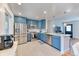 Bright kitchen features stainless steel appliances, blue cabinets, and granite countertops at 7621 Granada Rd, Denver, CO 80221