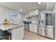 Well-lit kitchen with stainless steel appliances and barstool seating at 7621 Granada Rd, Denver, CO 80221