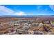 Expansive aerial view showcases neighborhood, mountain backdrop, and blue skies at 3230 S Decatur St, Denver, CO 80236