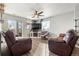 Bright living room features leather recliners, ceiling fan and sliding glass doors at 3230 S Decatur St, Denver, CO 80236