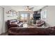 Spacious living room with leather furniture, ceiling fan, and sliding glass doors to outside view at 3230 S Decatur St, Denver, CO 80236