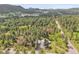 Scenic aerial view of a metal-roofed house and property amid a lush forest landscape at 26752 Vosler St, Conifer, CO 80433