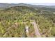 Expansive aerial shot showcasing a property with a house surrounded by lush forest scenery and rolling mountains at 26752 Vosler St, Conifer, CO 80433
