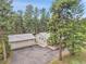 Aerial view of home and detached garage featuring asphalt driveway and metal roof, surrounded by tall trees at 26752 Vosler St, Conifer, CO 80433