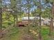 Exterior view of deck and home with light siding surrounded by tall trees and a green lawn at 26752 Vosler St, Conifer, CO 80433
