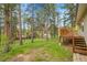 Backyard view of the house with a large wooden deck and green trees at 26752 Vosler St, Conifer, CO 80433