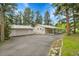 Exterior view showing paved driveway, carport and garage nestled amongst mature trees at 26752 Vosler St, Conifer, CO 80433