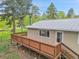 Exterior view of home featuring a wooden deck, light siding, and a metal roof at 26752 Vosler St, Conifer, CO 80433