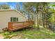 Exterior view of home featuring a wooden deck, light siding, and nestled in a wooded lot at 26752 Vosler St, Conifer, CO 80433