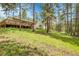Charming home featuring a spacious deck and surrounded by lush greenery and tall trees at 26752 Vosler St, Conifer, CO 80433
