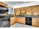 Bright kitchen boasts wood cabinets, black appliances and brick backsplash at 26752 Vosler St, Conifer, CO 80433